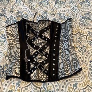 Floral jacquard corset with buckles and light chain details.